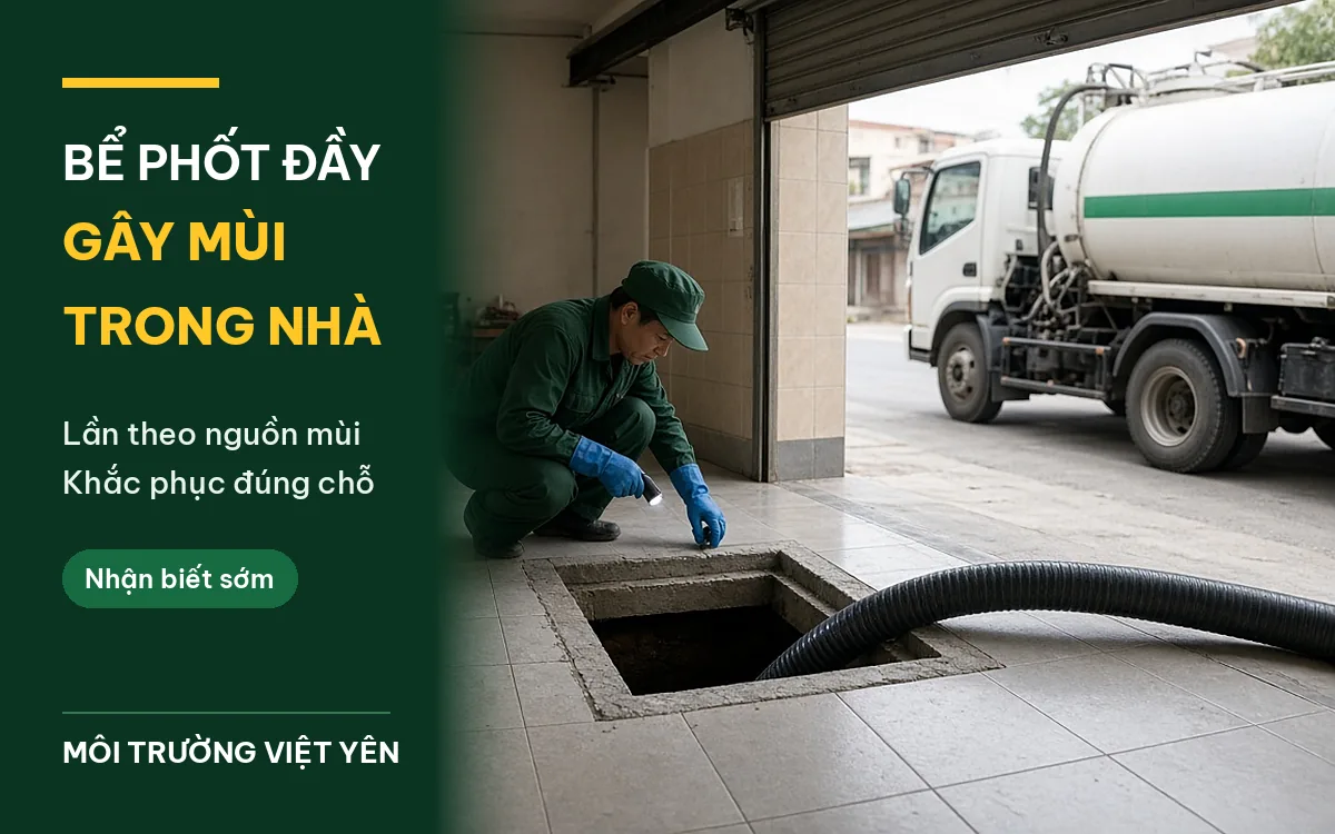 Kỹ thuật viên đồng phục xanh đậm đeo găng tay xanh ngồi xổm cầm đèn pin cạnh miệng bể phốt vuông đã mở trên nền gạch tầng một nhà ống, ống hút đen chạy vào bể, xe hút bể phốt trắng sọc xanh đỗ ngoài cửa cuốn, ảnh bìa bể phốt đầy gây mùi trong nhà