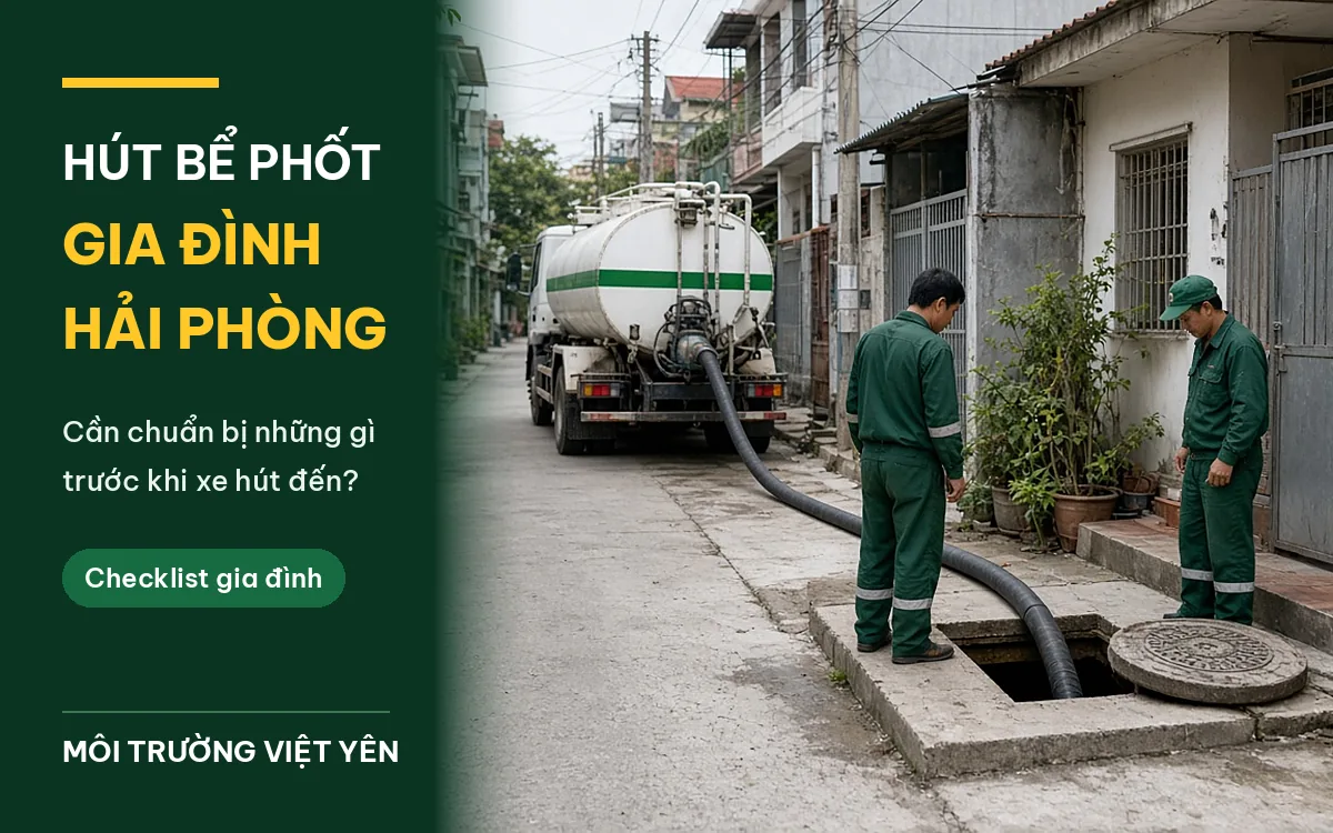 Xe hút bể phốt trắng sọc xanh đỗ trong ngõ dãy nhà dân, ống hút đen kéo tới nắp bể đã mở bên lề, hai kỹ thuật viên Môi Trường Việt Yên đồng phục xanh đứng cạnh, ảnh bìa hút bể phốt gia đình Hải Phòng