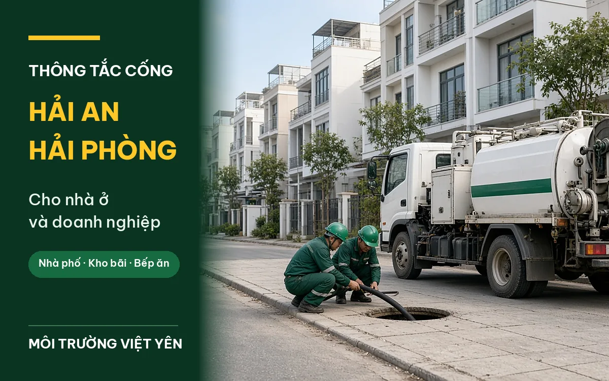 Hai kỹ thuật viên Môi Trường Việt Yên đội mũ bảo hộ xanh đưa ống từ xe chuyên dụng xuống hố ga vỉa hè trên phố nhà liền kề ở Hải An